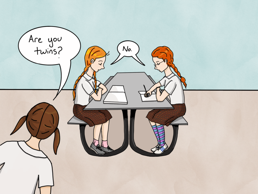 Two red-haired girls in school uniforms sit at a table. Another student leans into the picture and asks, "Are you twins?" The redheads respond "no" together.